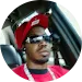 Man wearing headphones and sunglasses, smiling in circular profile photo for dentures website.