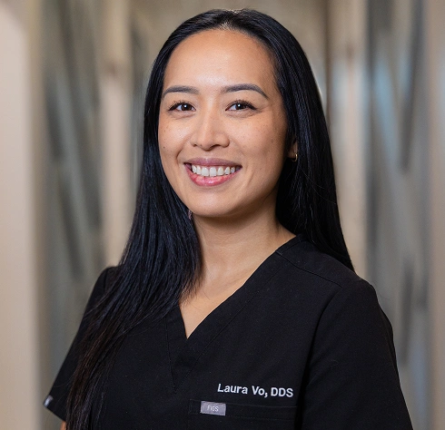 Professional headshot of Laura Vu, DDS, wearing black scrubs against a neutral background.